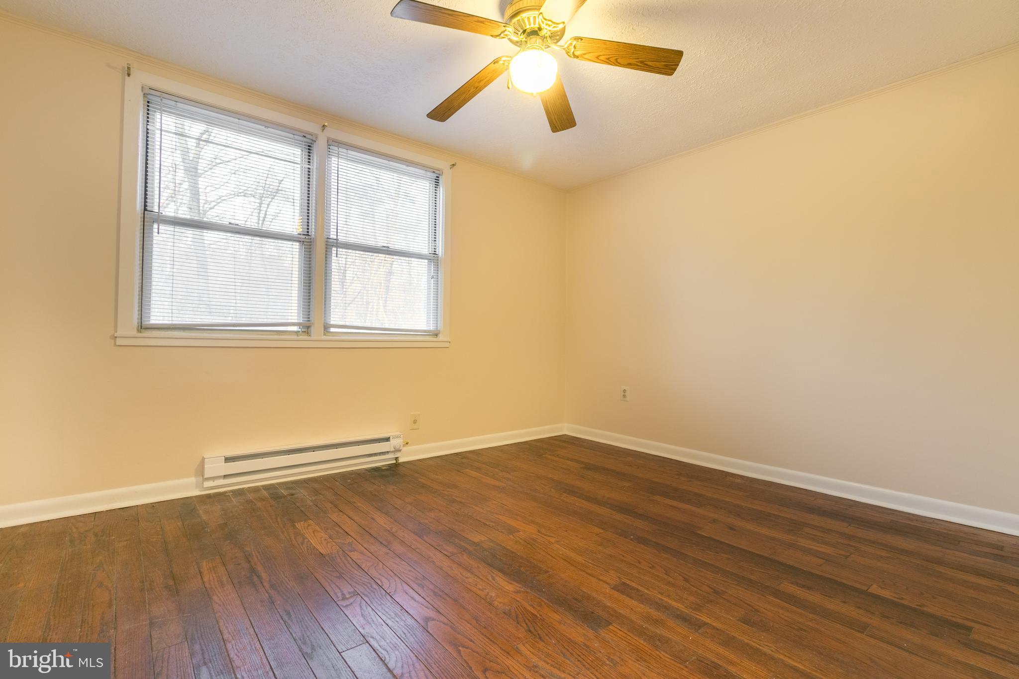 62 Ridge Road, Unit C Greenbelt, MD 20770 - Photo 7 of 9 an empty room with wooden floor fan and windows