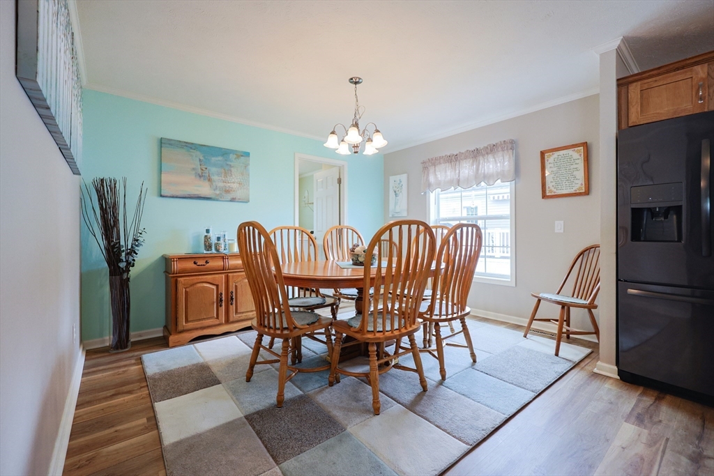 12 Linsay Drive Raynham, MA 02767 - Photo 14 of 28 a dining room with furniture a chandelier and wooden floor