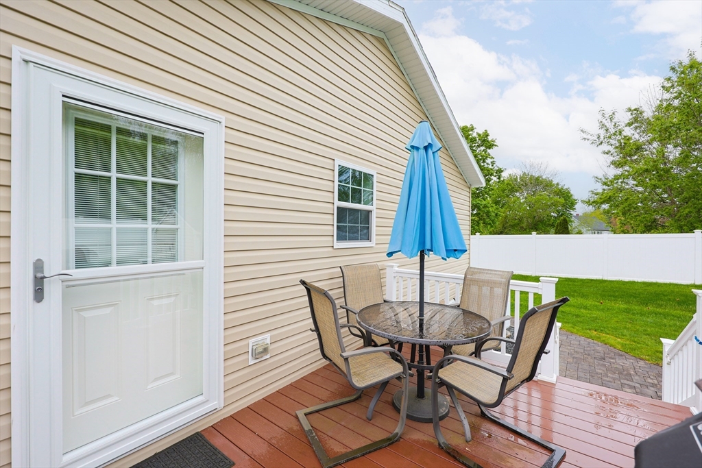 12 Linsay Drive Raynham, MA 02767 - Photo 24 of 28 a view of a patio with table and chairs with wooden floor and fence