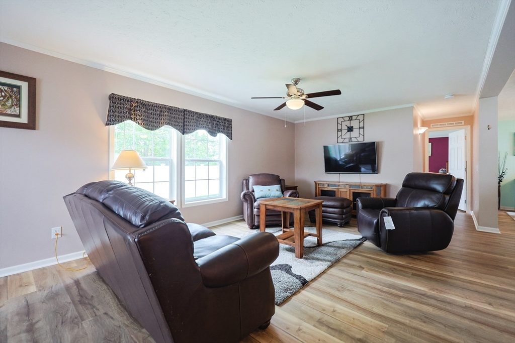 12 Linsay Drive Raynham, MA 02767 - Photo 6 of 28 a living room with furniture a fireplace and a flat screen tv