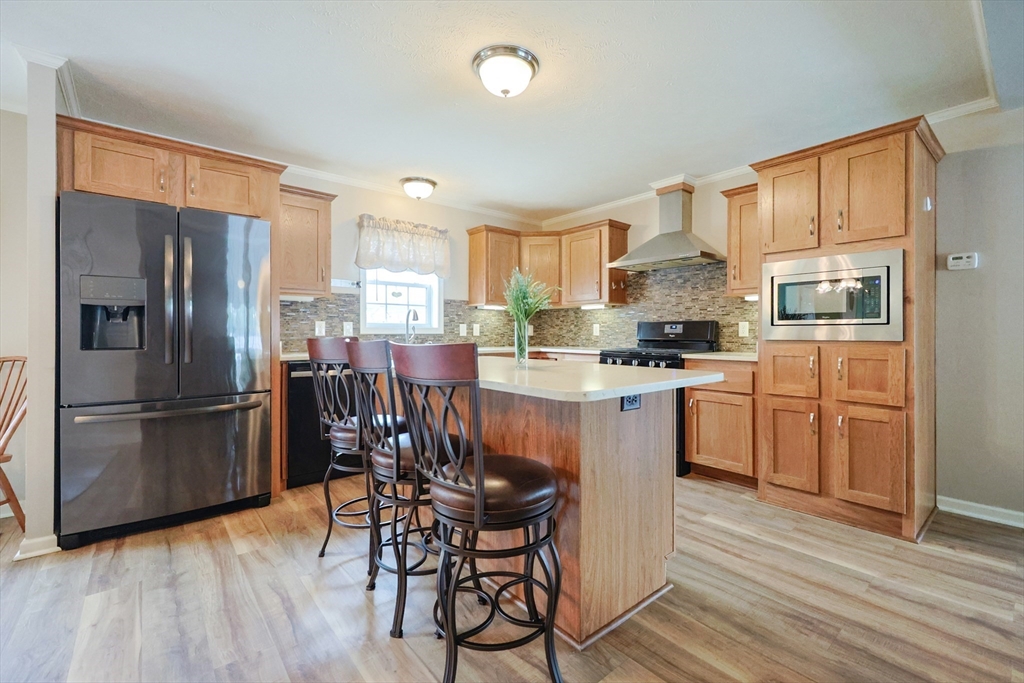 12 Linsay Drive Raynham, MA 02767 - Photo 7 of 28 a kitchen with a table chairs refrigerator and microwave