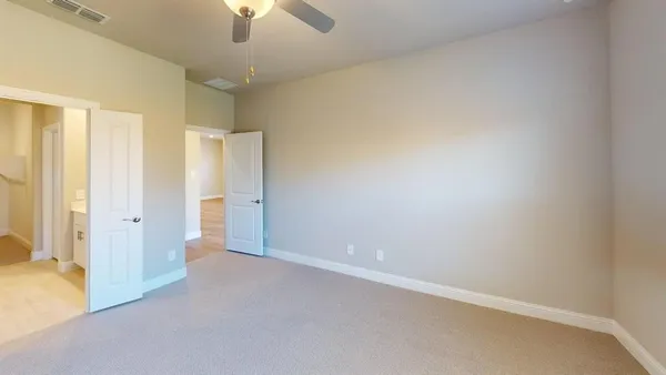 an empty room with a ceiling fan and a window