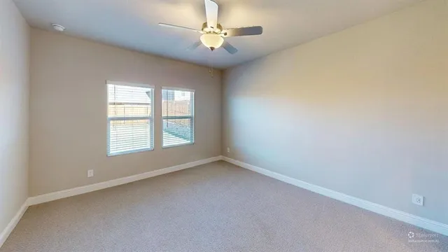 an empty room with a window and a fan