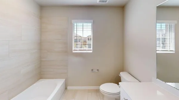 a white toilet sitting next to a bath tub