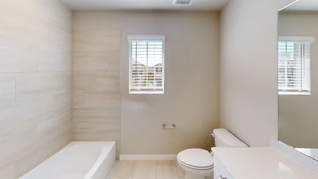 a white toilet sitting next to a bath tub