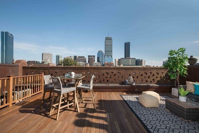 a view of a balcony with dining table and chairs