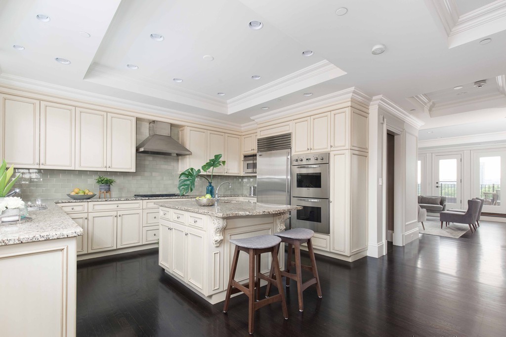 348 Beacon Street, Unit PH Boston, MA 02116 - Photo 4 of 34 a kitchen with white cabinets and stainless steel appliances