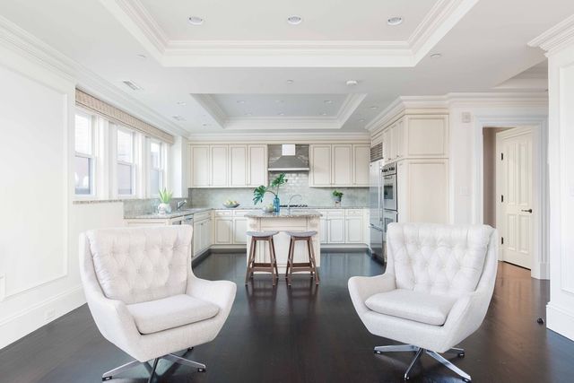 a living room with couches a coffee table and chair with wooden floor