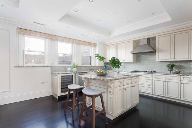 a kitchen with stainless steel appliances white cabinets and wooden floor