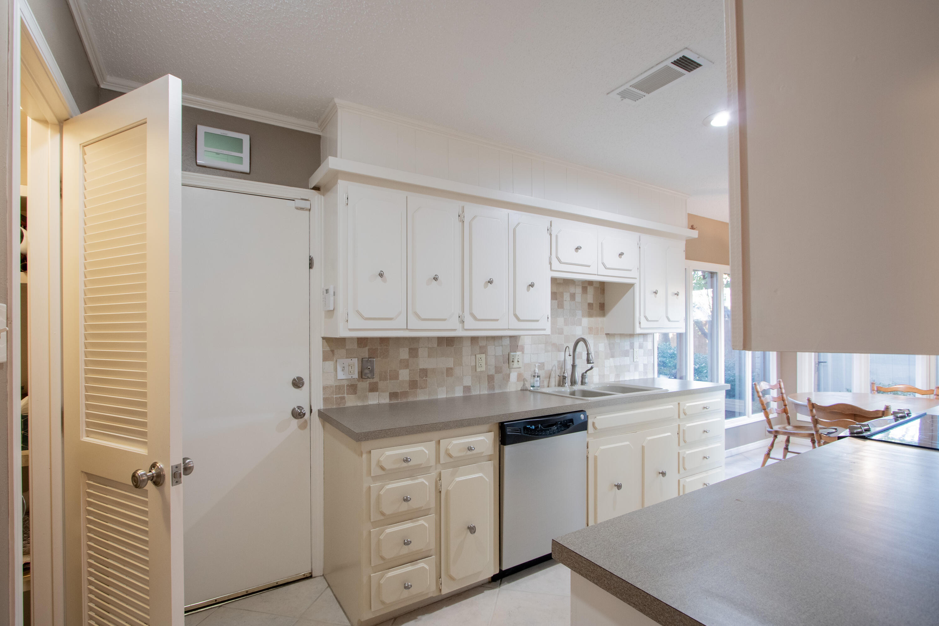 3722 63rd Drive Lubbock, TX 79413 - Photo 20 of 63 a kitchen with a sink dishwasher a stove and white cabinets