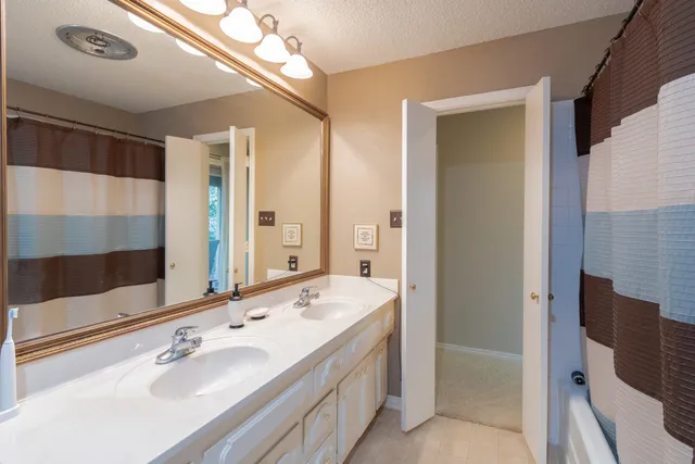 a view of a backyard with large trees and a barn