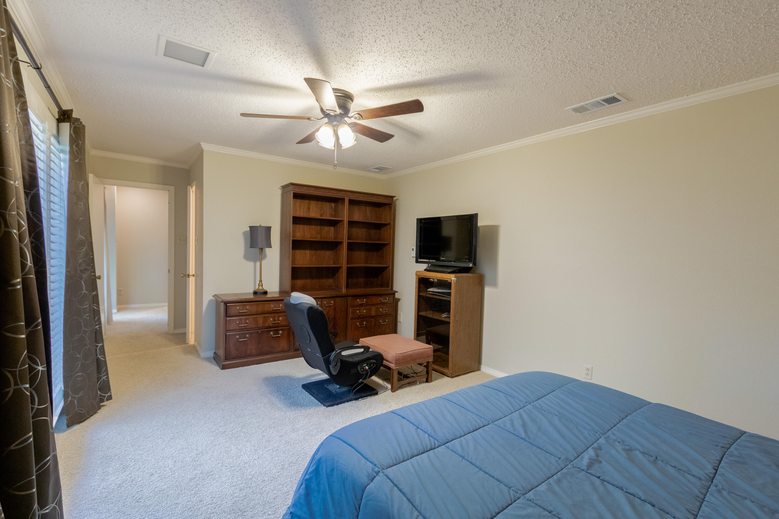 3722 63rd Drive Lubbock, TX 79413 - Photo 51 of 63 a view of a bedroom with workspace and a ceiling fan
