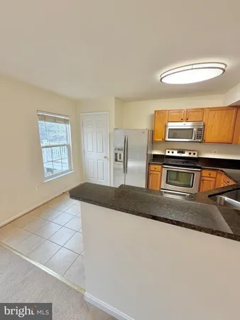 a view of kitchen with stainless steel appliances granite countertop sink and stove