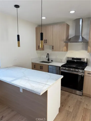 a kitchen with kitchen island a sink stainless steel appliances and a counter top space