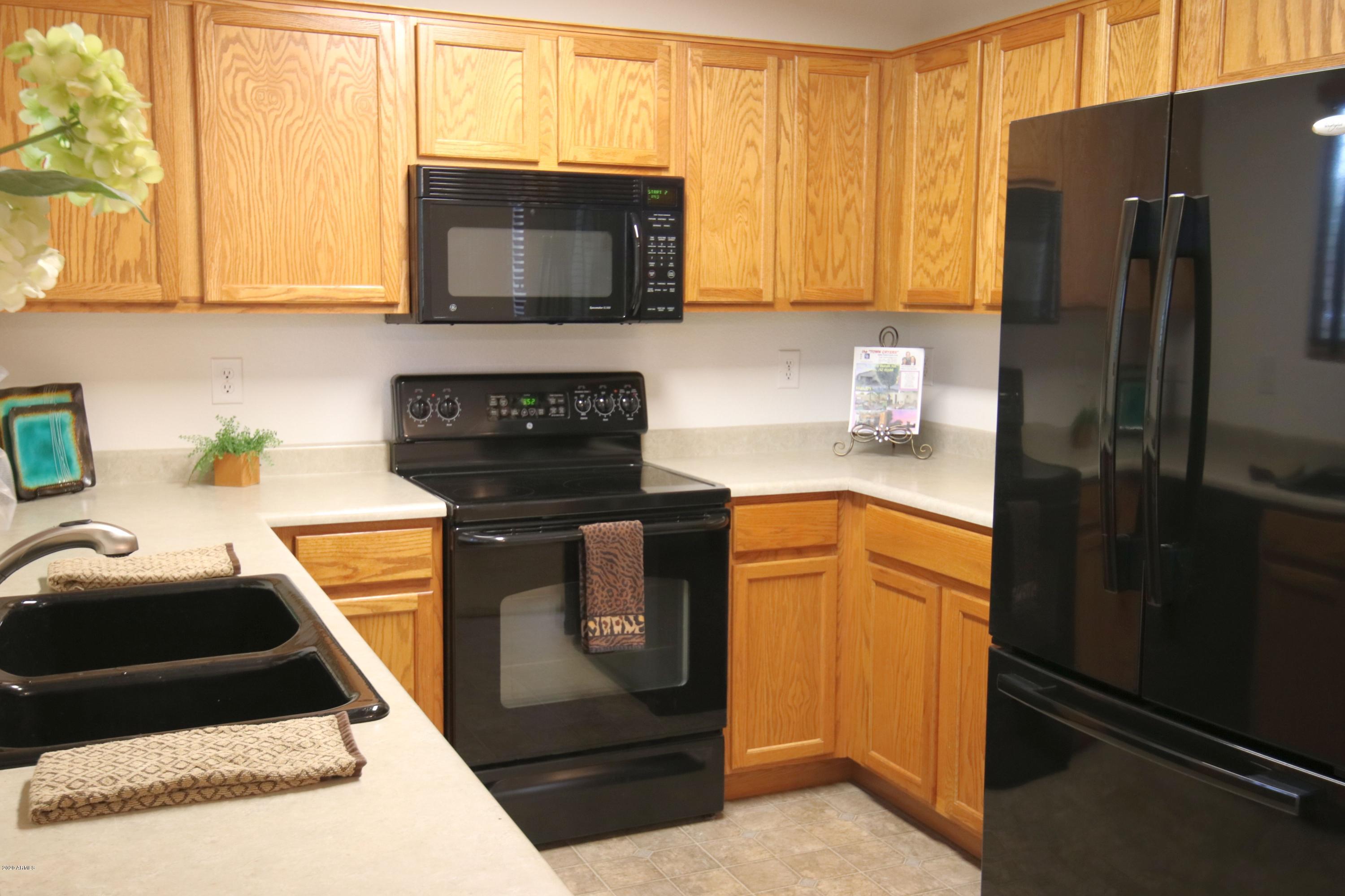17531 West Boca Raton Road Surprise, AZ 85388 - Photo 5 of 32 a kitchen with a stove microwave and refrigerator