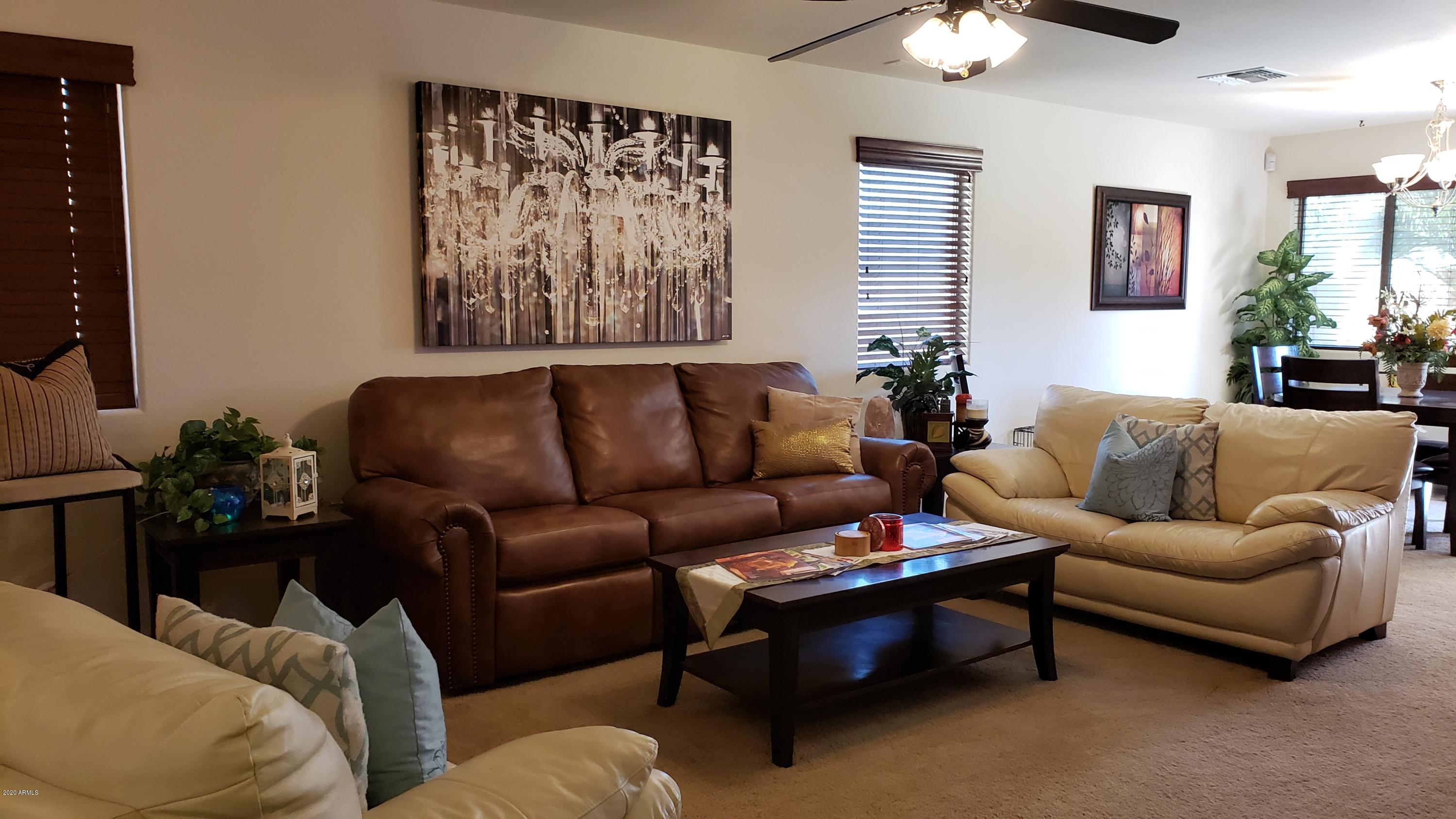 17531 West Boca Raton Road Surprise, AZ 85388 - Photo 8 of 32 a living room with furniture a couch and chandelier