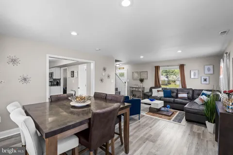 a living room with furniture dining table and wooden floor
