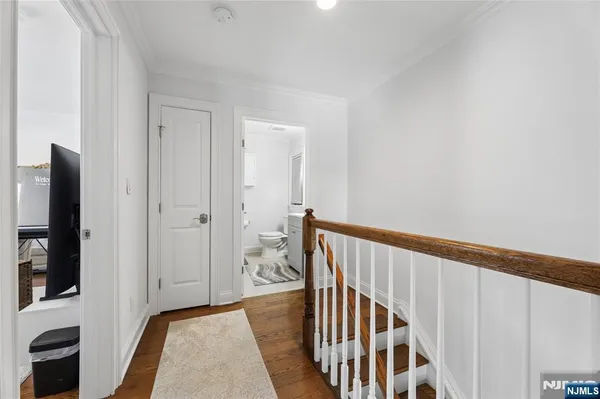 a view of a hallway with wooden floor and staircase
