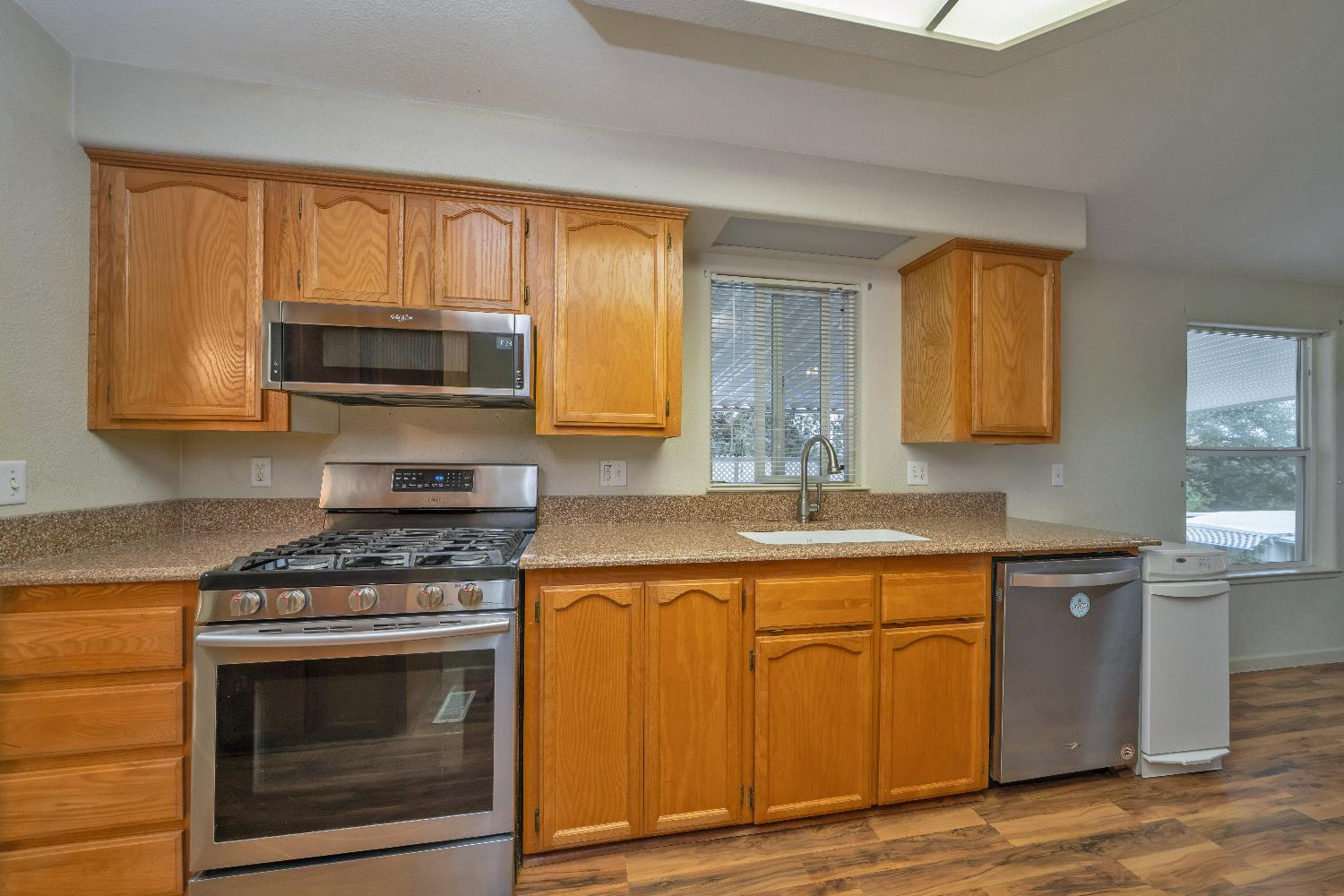 3550 China Garden Road, Unit 102 Placerville, CA 95667 - Photo 12 of 30 a kitchen with granite countertop a stove top oven microwave and cabinets