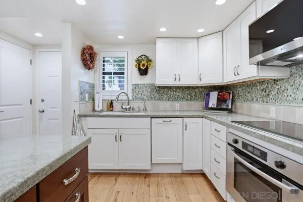 a kitchen with granite countertop white cabinets and white appliances