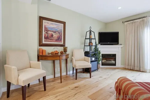 a living room with furniture a flat screen tv and a fireplace