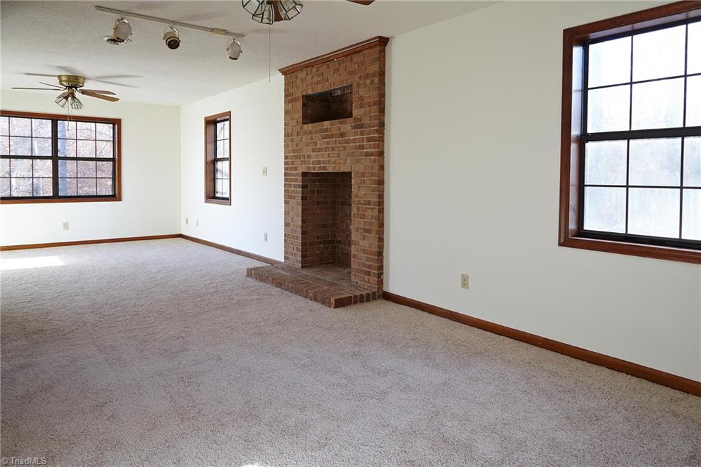 544 Neal Road Madison, NC 27025 - Photo 14 of 28 Huge master bedroom on second level with a fireplace, skylight, new carpet, and a sitting area. Window on the left overlooks the pond.