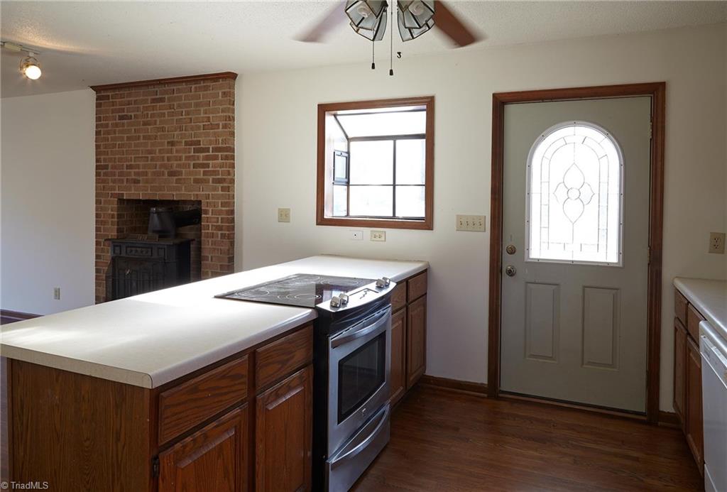 544 Neal Road Madison, NC 27025 - Photo 8 of 28 View of the kitchen peninsula overlooking the living area and wood stove. Kitchen door with leaded glass, and window box for plants.