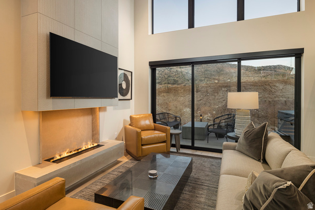 213 Lionsback Loop, Unit 38 Moab, UT 84532 - Photo 4 of 26 Living area featuring a floor-to-ceiling fireplace with a linear burner, high ceilings, and expansive sliding glass doors
