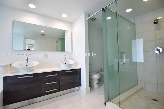 a bathroom with a granite countertop sink mirror and toilet