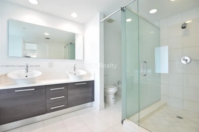 a bathroom with a sink shower and a mirror