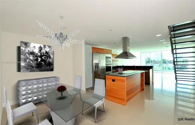 a kitchen with stainless steel appliances kitchen island granite countertop a table and chairs in it