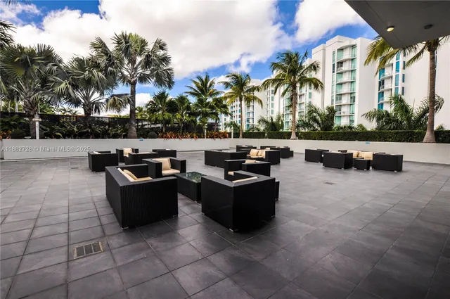 a living room with patio furniture and a fire pit