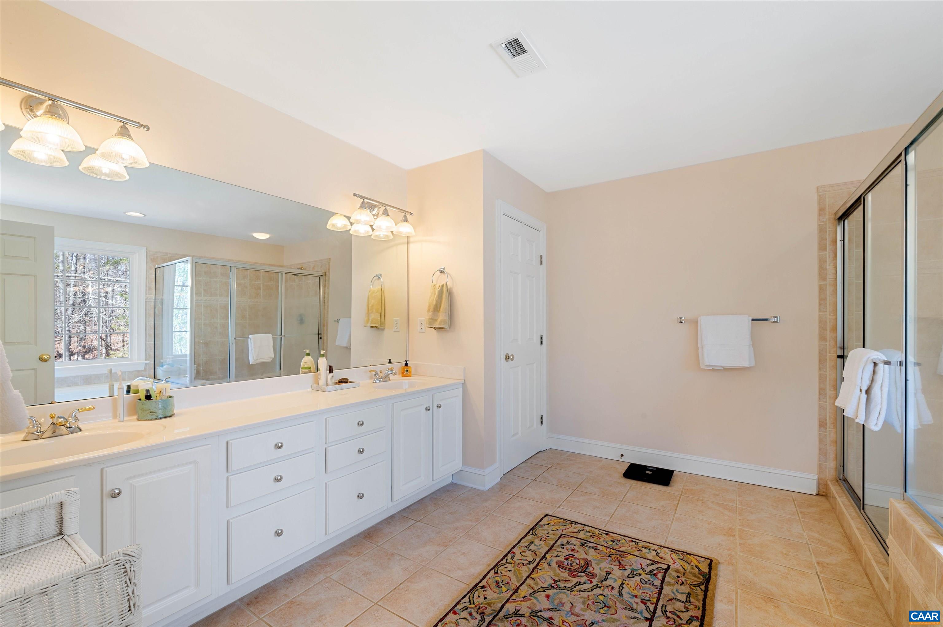 891 Old Ballard Road Charlottesville, VA 22901 - Photo 29 of 49 a spacious bathroom with a double vanity sink a mirror and a bathtub