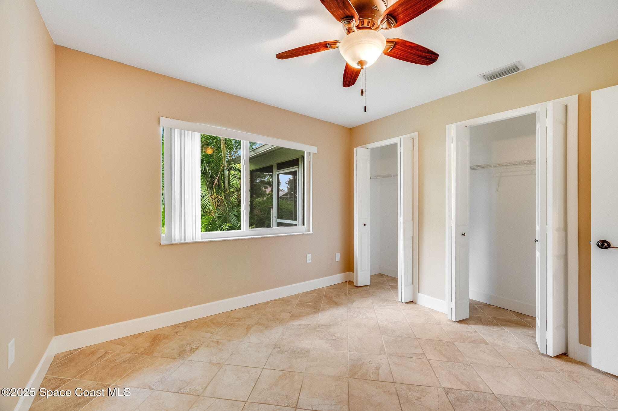 7081 Bayfront Road Cocoa, FL 32927 - Photo 17 of 45 a view of an empty room with window and chandelier fan