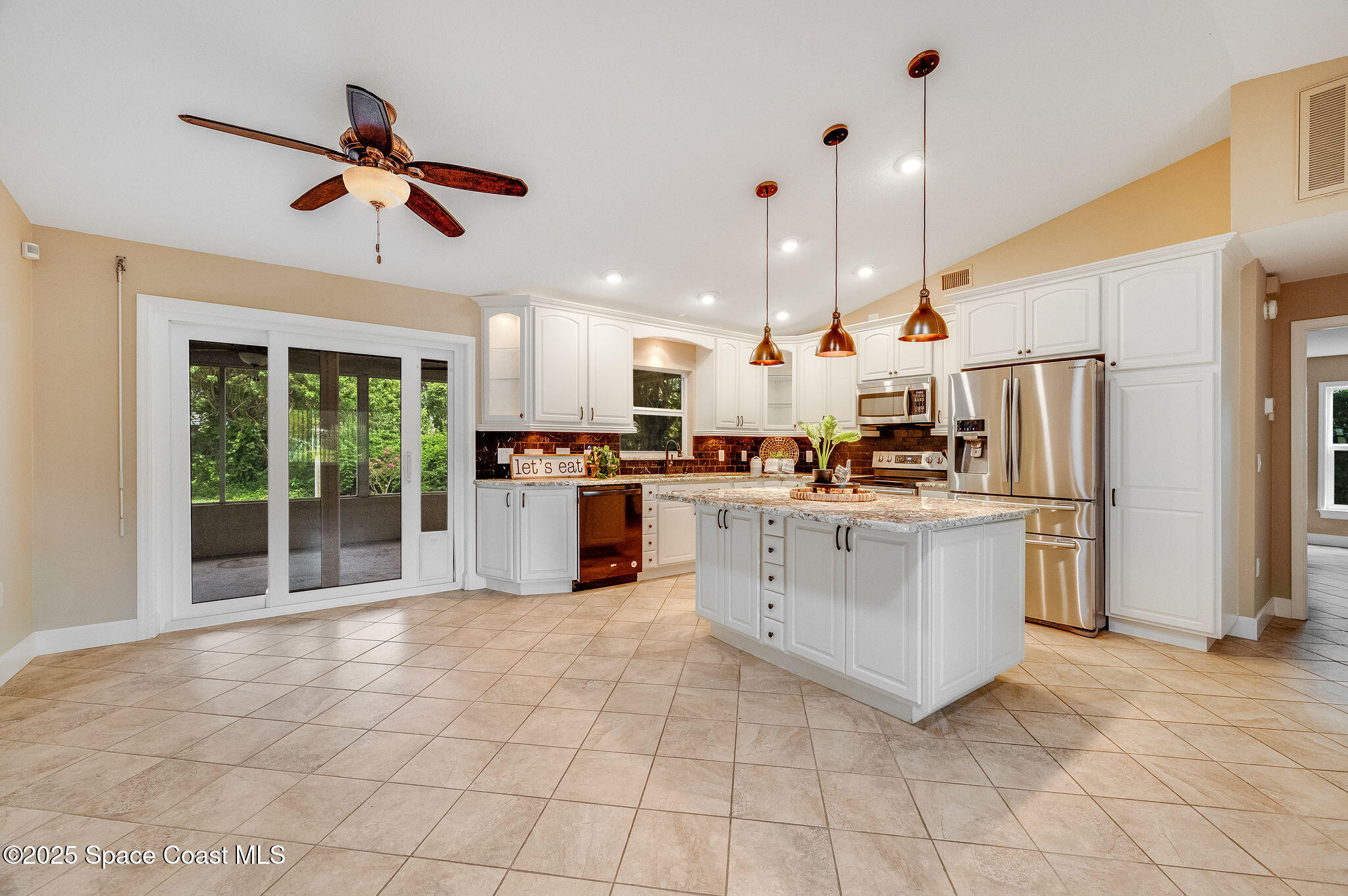 7081 Bayfront Road Cocoa, FL 32927 - Photo 3 of 45 a kitchen with stainless steel appliances kitchen island granite countertop a refrigerator a oven a sink and a stove