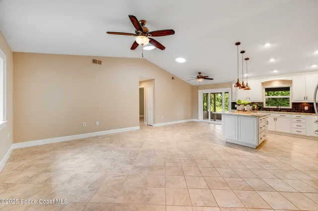 a kitchen with kitchen island white cabinets and stainless steel appliances