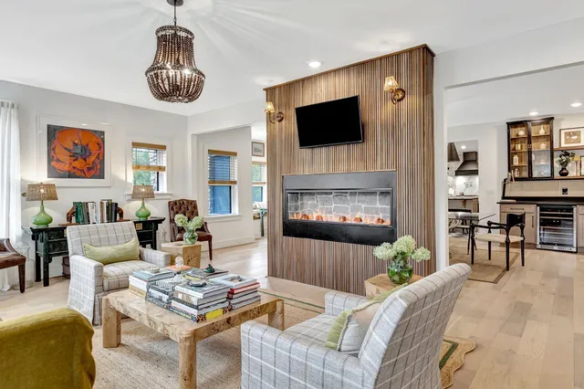 a kitchen with stainless steel appliances granite countertop a stove top oven a sink a dining table and chairs with wooden floor