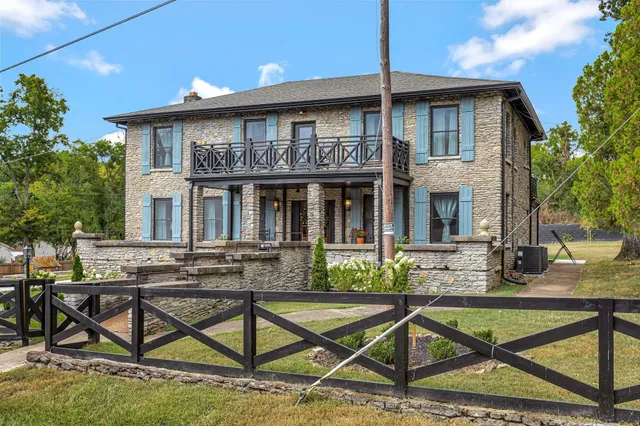 a view of house with chairs and wooden fence