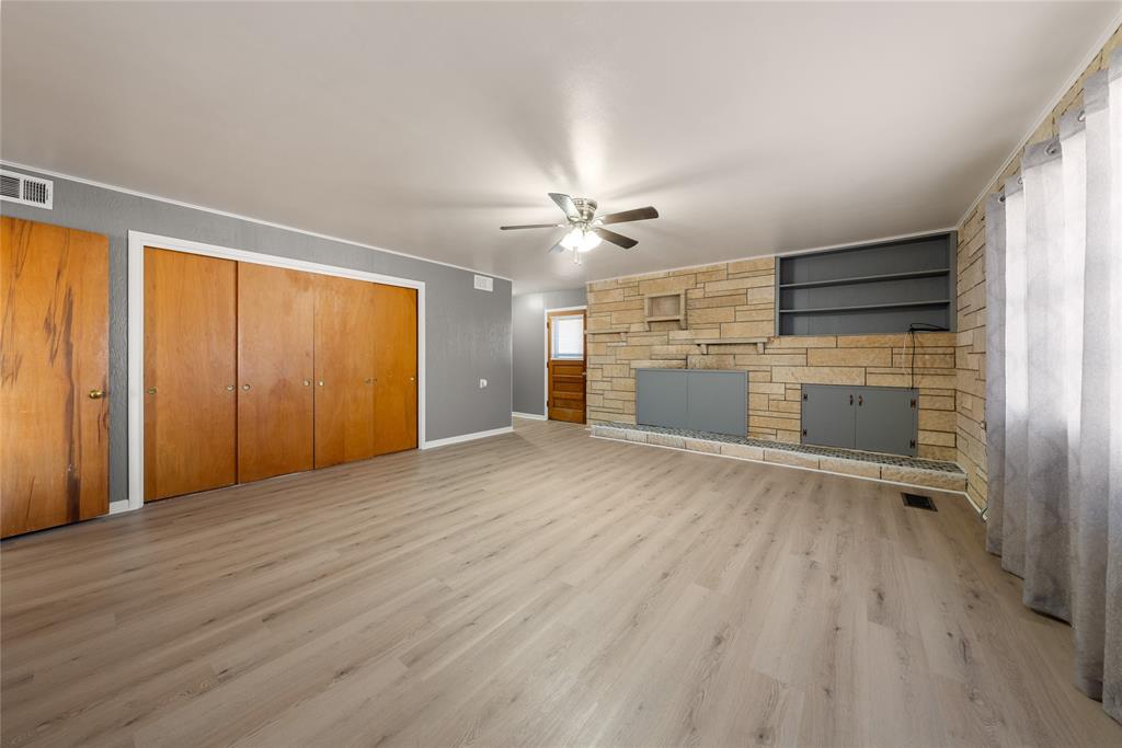 10652 Corbell Road Brady, TX 76825 - Photo 11 of 38 an empty room with wooden floor cabinet and windows