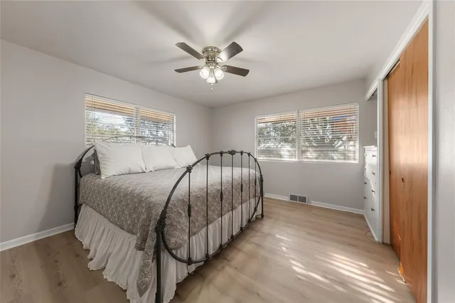 a spacious bedroom with a bed and wooden floor