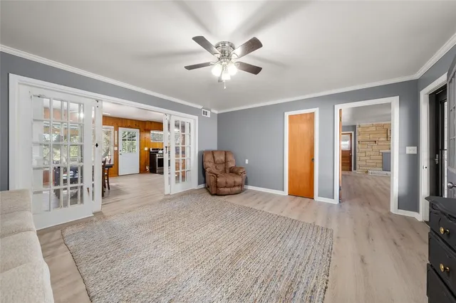 a view of a livingroom with wooden floor and a ceiling fan