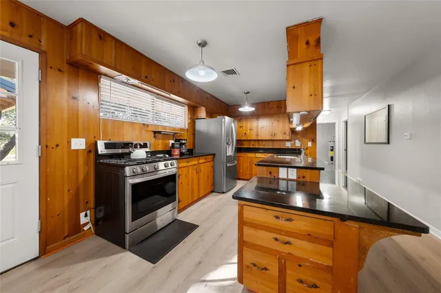 a kitchen with stainless steel appliances granite countertop a stove a sink and a refrigerator