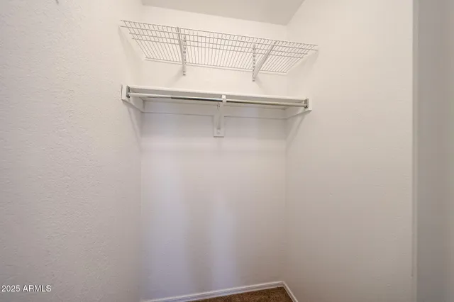 an empty room with windows and ceiling fan