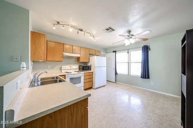 a kitchen that has a lot of cabinets and wooden floor