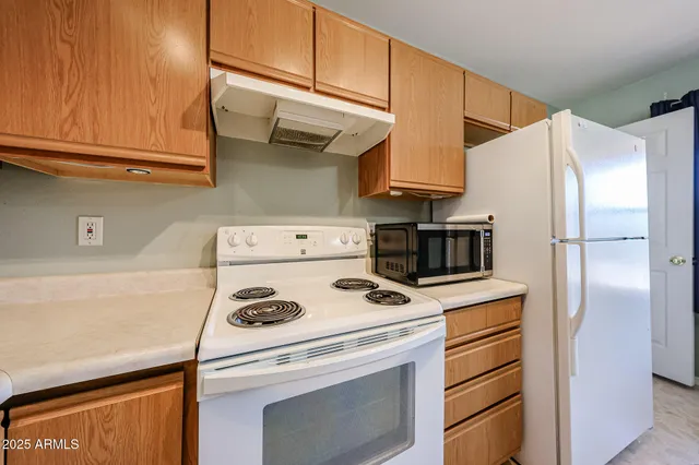 a kitchen with stainless steel appliances granite countertop a refrigerator and a stove