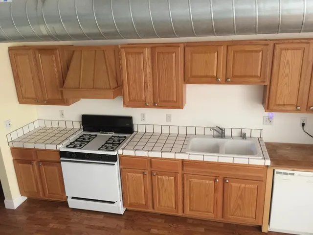 a kitchen with a stove a refrigerator and a sink
