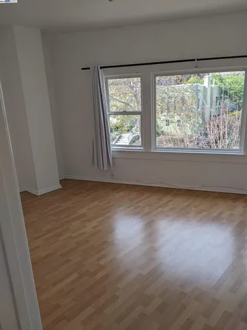 an empty room with fan and windows