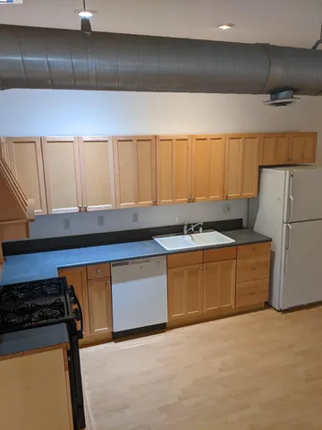 a kitchen with a stove a refrigerator and wooden cabinets