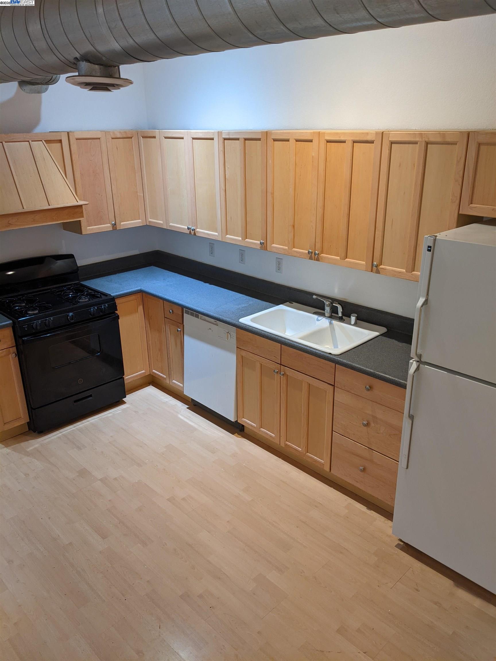 2622 Kingsland Avenue Oakland, CA 94619 - Photo 6 of 29 a kitchen with stainless steel appliances a refrigerator a sink and wooden cabinets