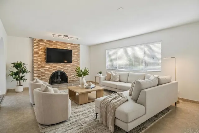 a living room with furniture a flat screen tv and a large window